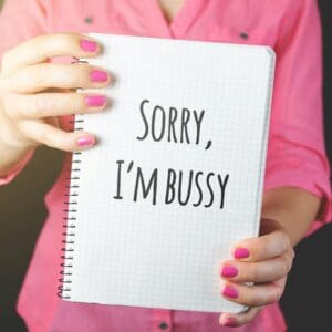 Person holding notebook with 'SORRY, I'M BUSSY' message.