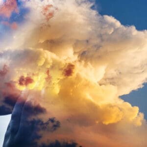 Golden sunlight illuminates towering clouds against a blue sky.