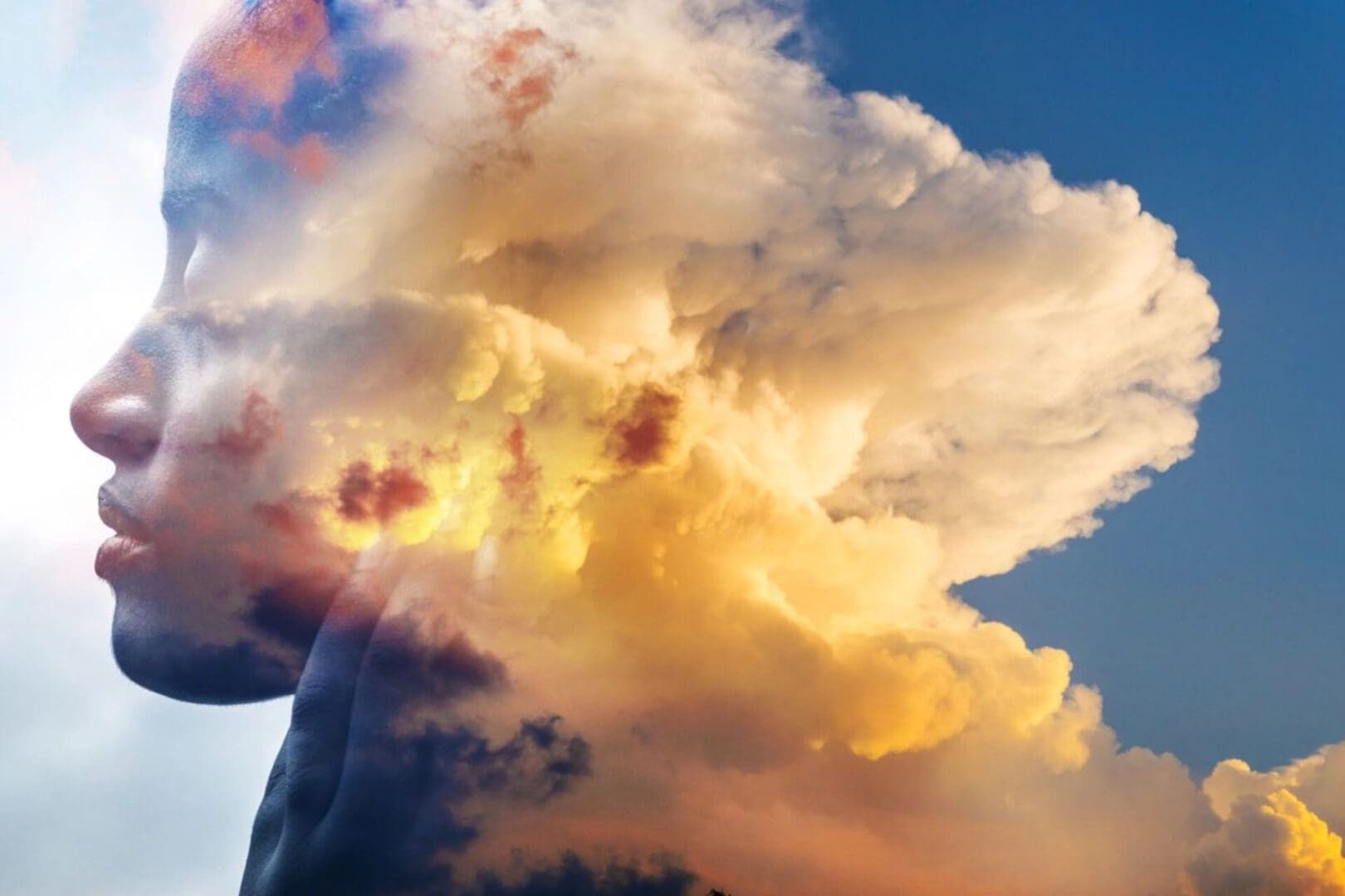 Golden sunlight illuminates towering clouds against a blue sky.