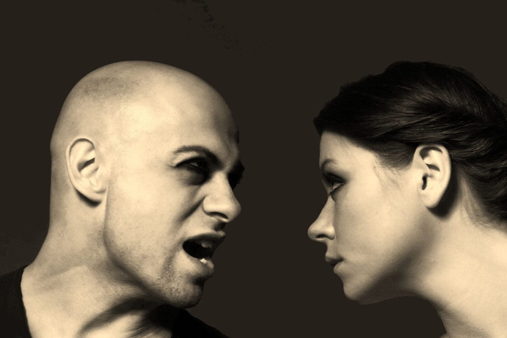 A tense confrontation between a bald man and a woman staring intensely.