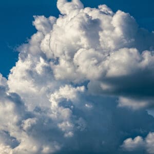 Fluffy white clouds against a deep blue sky.