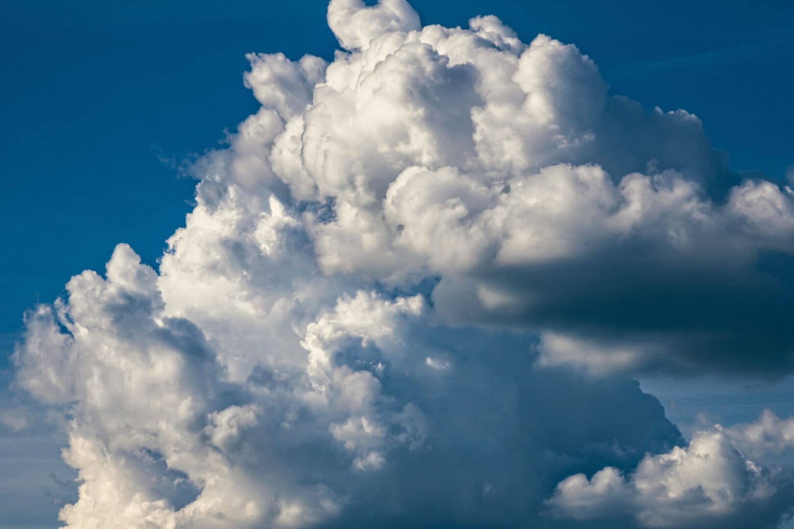 Fluffy white clouds against a deep blue sky.