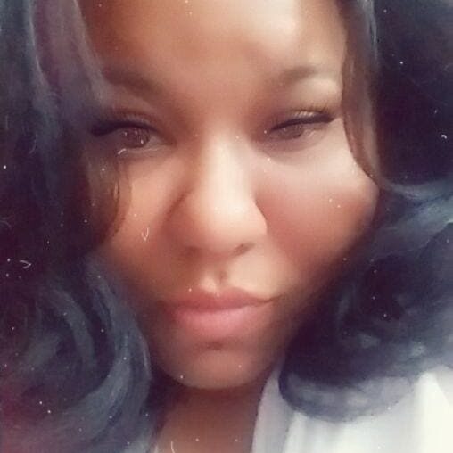 Close-up portrait of a woman with long dark hair and a calm expression.